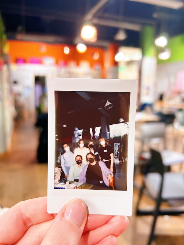 A Polaroid picture of 6 diverse meet-up organisers in masks